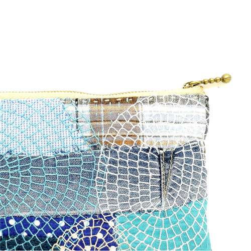 Fragment de pochette à fermeture éclair brodée à la main - tissu bleu avec broderie au point de couverture et fermeture éclair métallique
